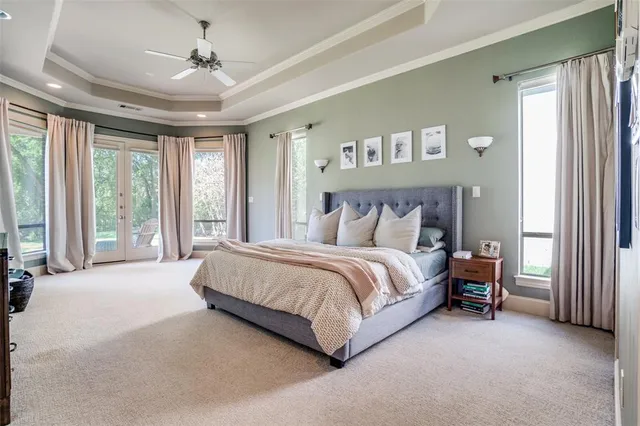a spacious bedroom with a large bed and a chandelier