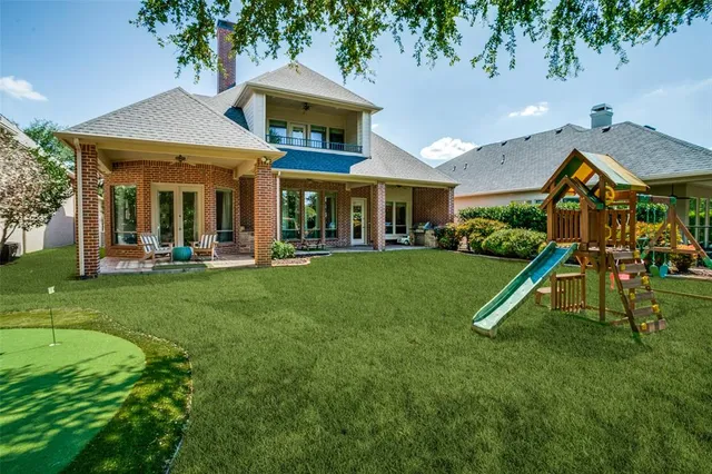 a view of a house with a yard patio and a slide
