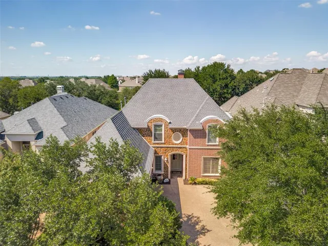 an aerial view of a house with a big yard and large tree