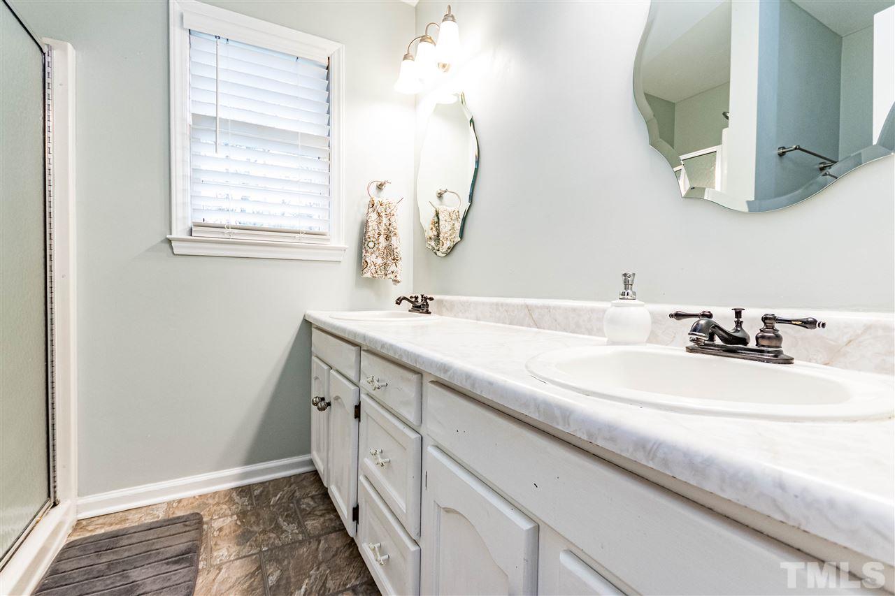 9908 Waterview Road Raleigh, NC 27615 - Photo 14 of 30 a bathroom with a double vanity sink and a mirror