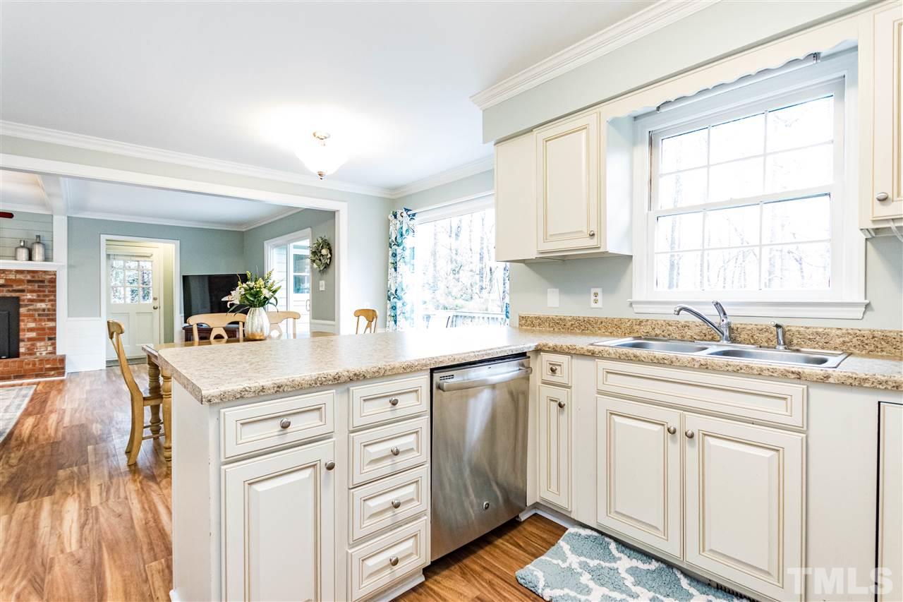 9908 Waterview Road Raleigh, NC 27615 - Photo 7 of 30 a kitchen with kitchen island granite countertop a sink window and cabinets