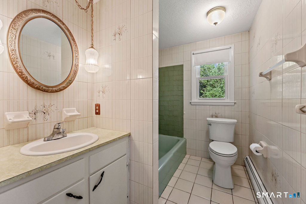 142 Wolcott Hill Road Wethersfield, CT 06109 - Photo 19 of 29 a bathroom with a sink a toilet and a mirror