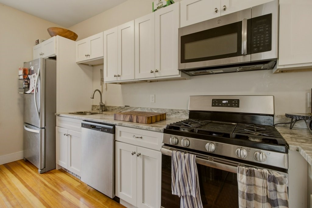 244 Camp Street, Unit 1 Providence, RI 02906 - Photo 11 of 26 Beautiful white "shaker-style" cabinets and stainless appliances complement the granite countertops in the spacious kitchen workspace.