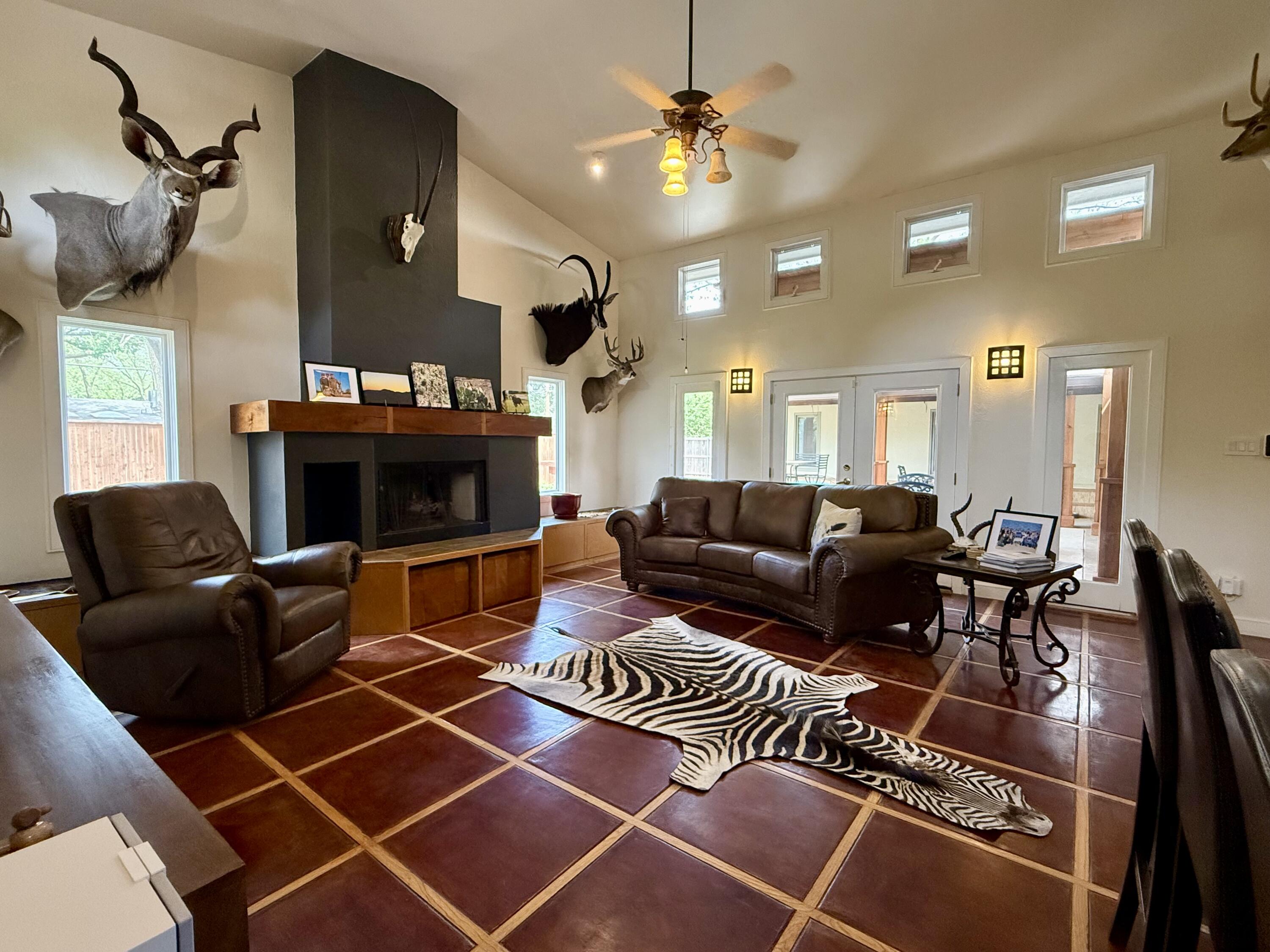 4406 15th Street Lubbock, TX 79416 - Photo 23 of 61 a living room with furniture a fireplace and a ceiling fan