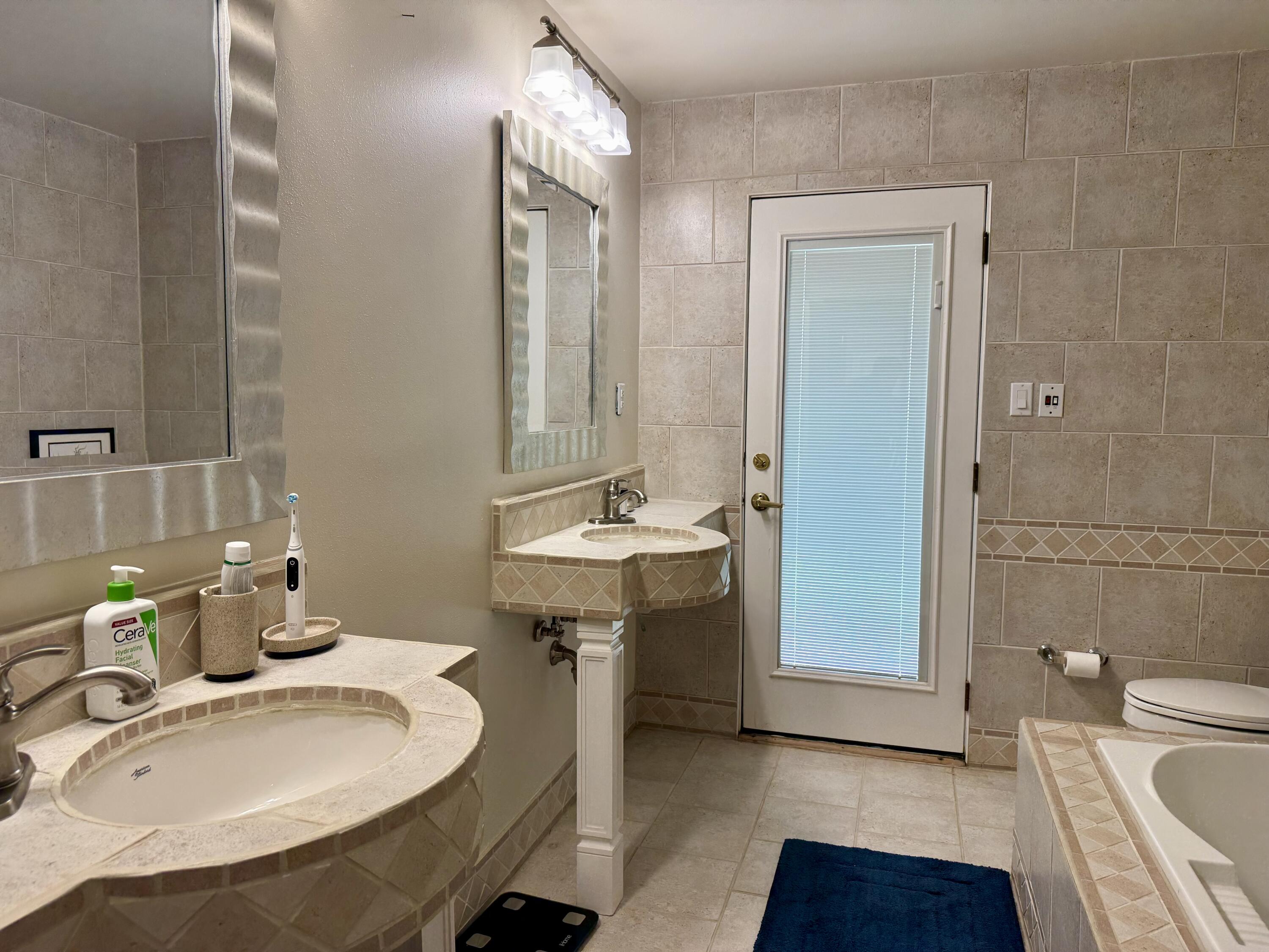 4406 15th Street Lubbock, TX 79416 - Photo 30 of 61 a bathroom with a sink and a mirror