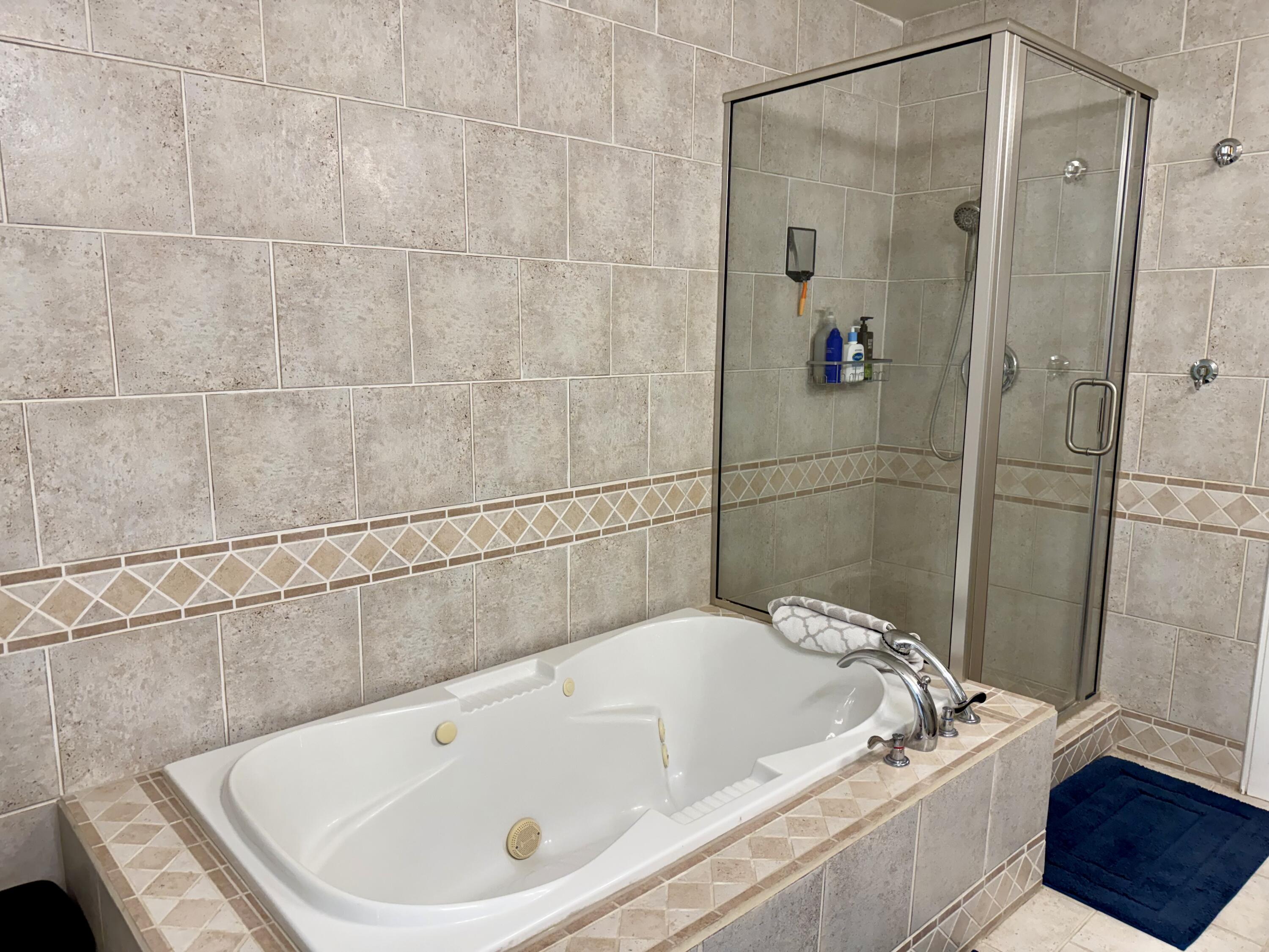 4406 15th Street Lubbock, TX 79416 - Photo 31 of 61 a bath tub sitting next to a white sink and a shower