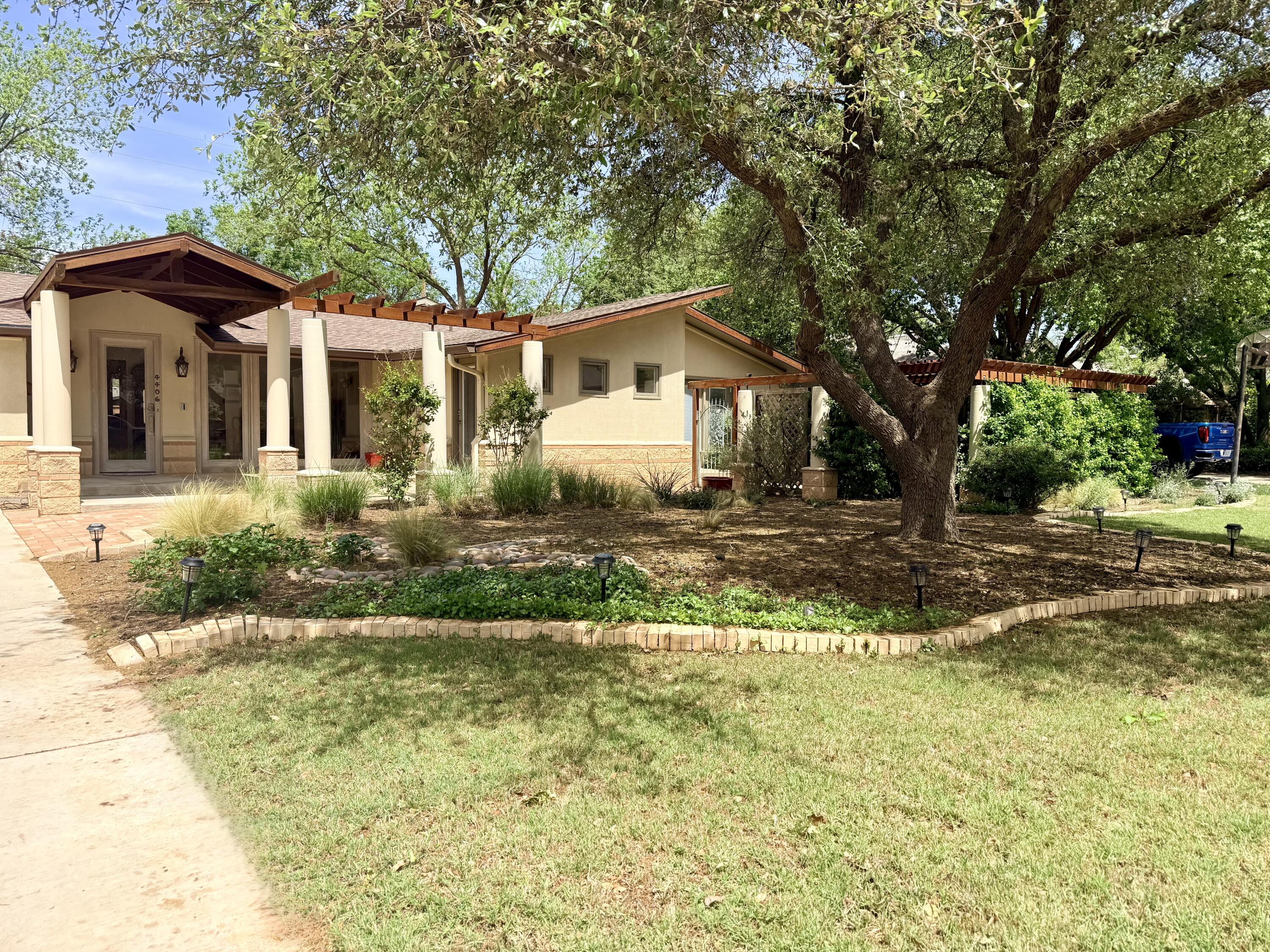 4406 15th Street Lubbock, TX 79416 - Photo 4 of 61 a front view of a house with garden