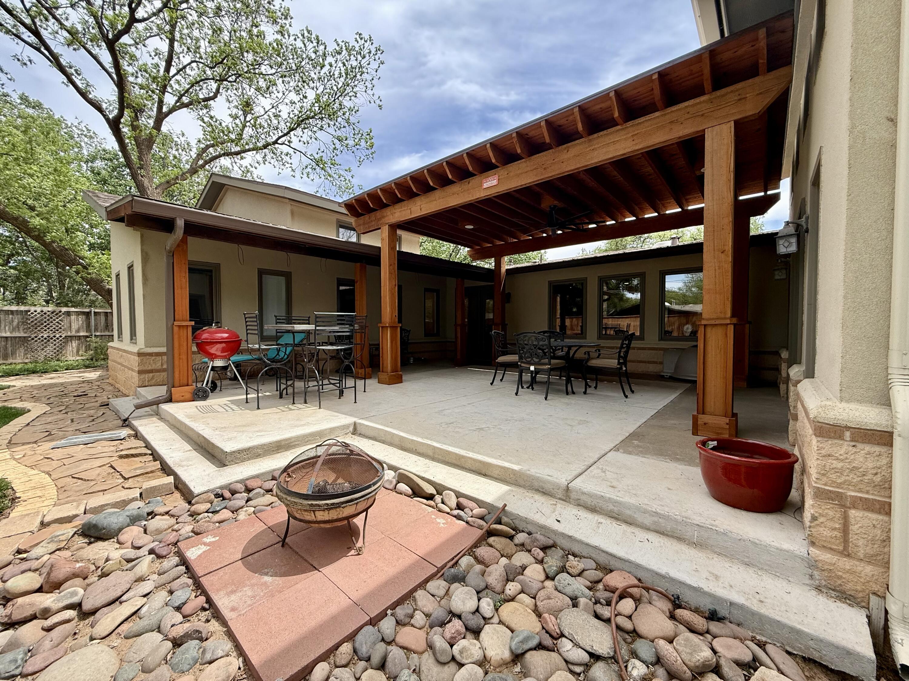 4406 15th Street Lubbock, TX 79416 - Photo 46 of 61 a view of a patio with table and chairs potted plants and large tree