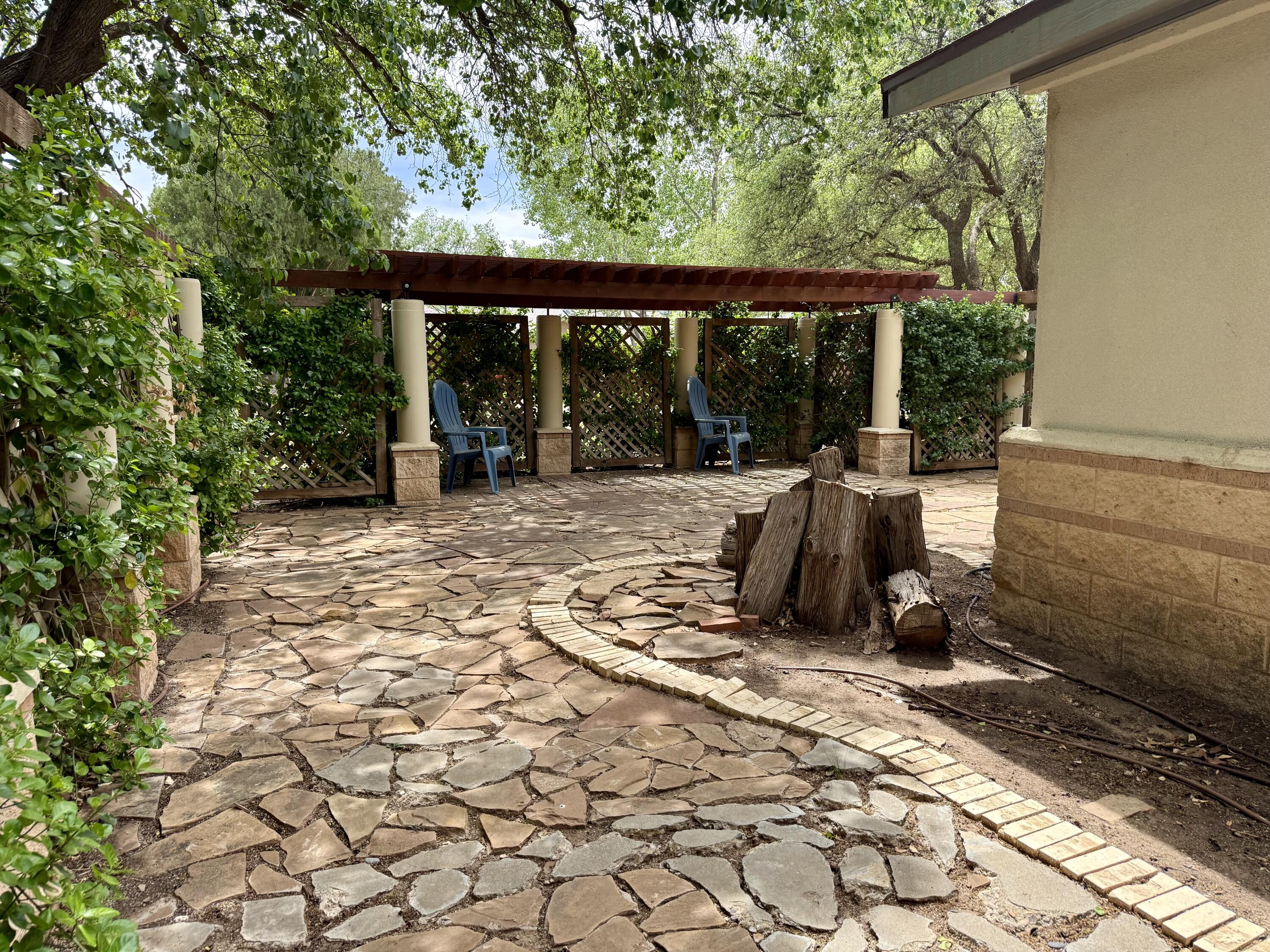 4406 15th Street Lubbock, TX 79416 - Photo 55 of 61 a view of a patio with a table and chairs under an umbrella with a large tree