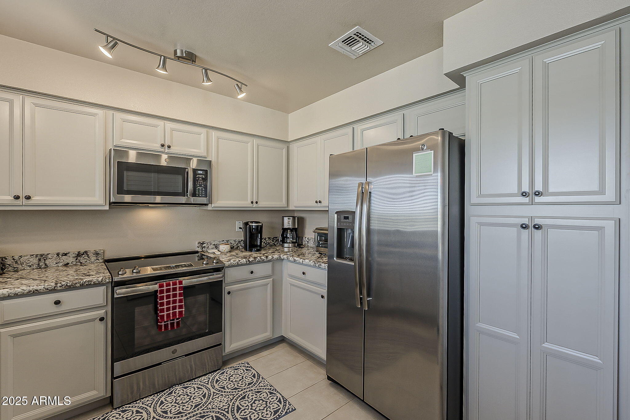 9707 East Mountain View Road, Unit 2412 Scottsdale, AZ 85258 - Photo 14 of 43 a kitchen with stainless steel appliances granite countertop a refrigerator and a stove top oven