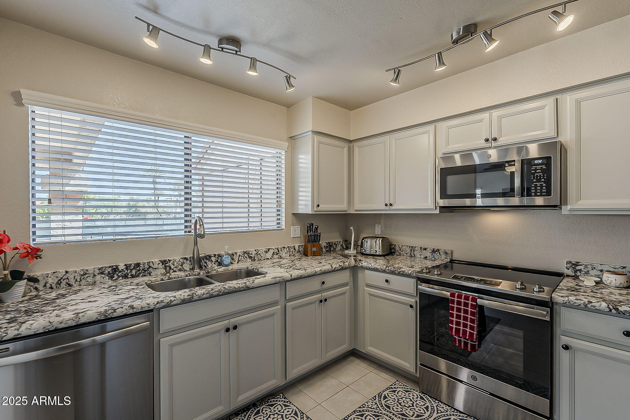 9707 East Mountain View Road, Unit 2412 Scottsdale, AZ 85258 - Photo 15 of 43 a kitchen with stainless steel appliances granite countertop a sink and a stove