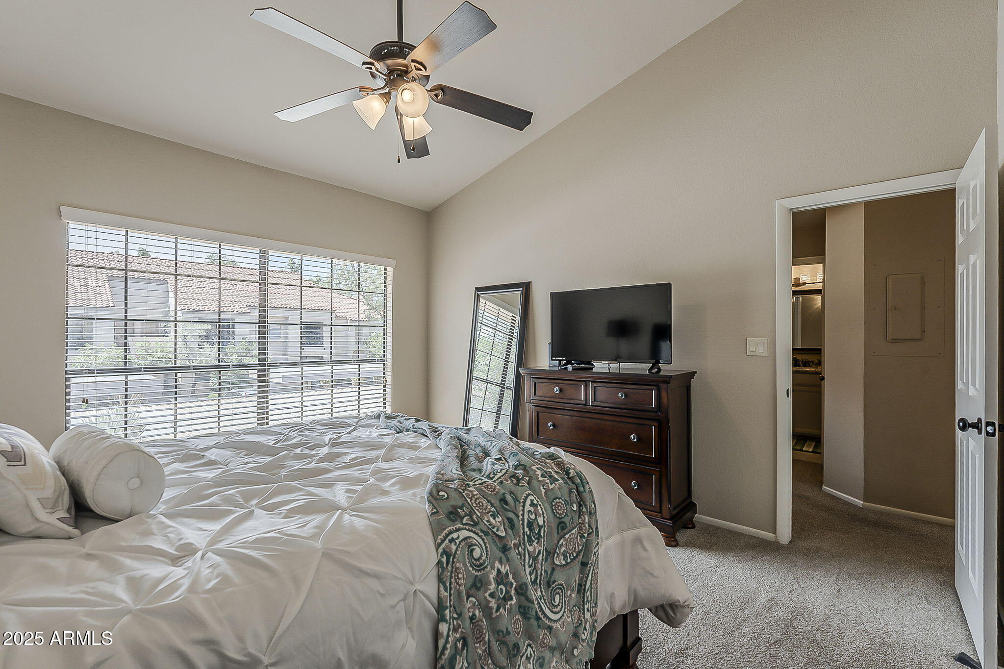 9707 East Mountain View Road, Unit 2412 Scottsdale, AZ 85258 - Photo 22 of 43 a bedroom with a balcony a bed and a television