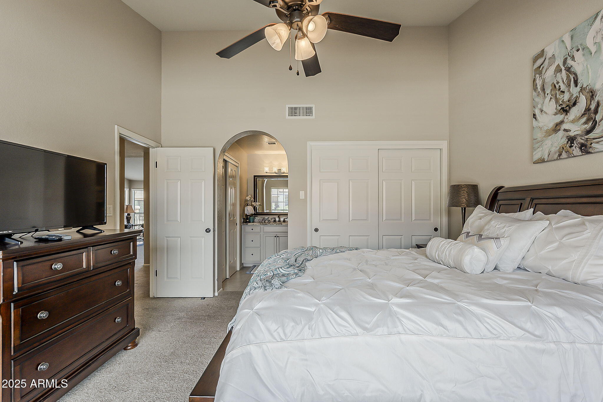 9707 East Mountain View Road, Unit 2412 Scottsdale, AZ 85258 - Photo 25 of 43 a bedroom with a bed and a flat tv screen on dresser