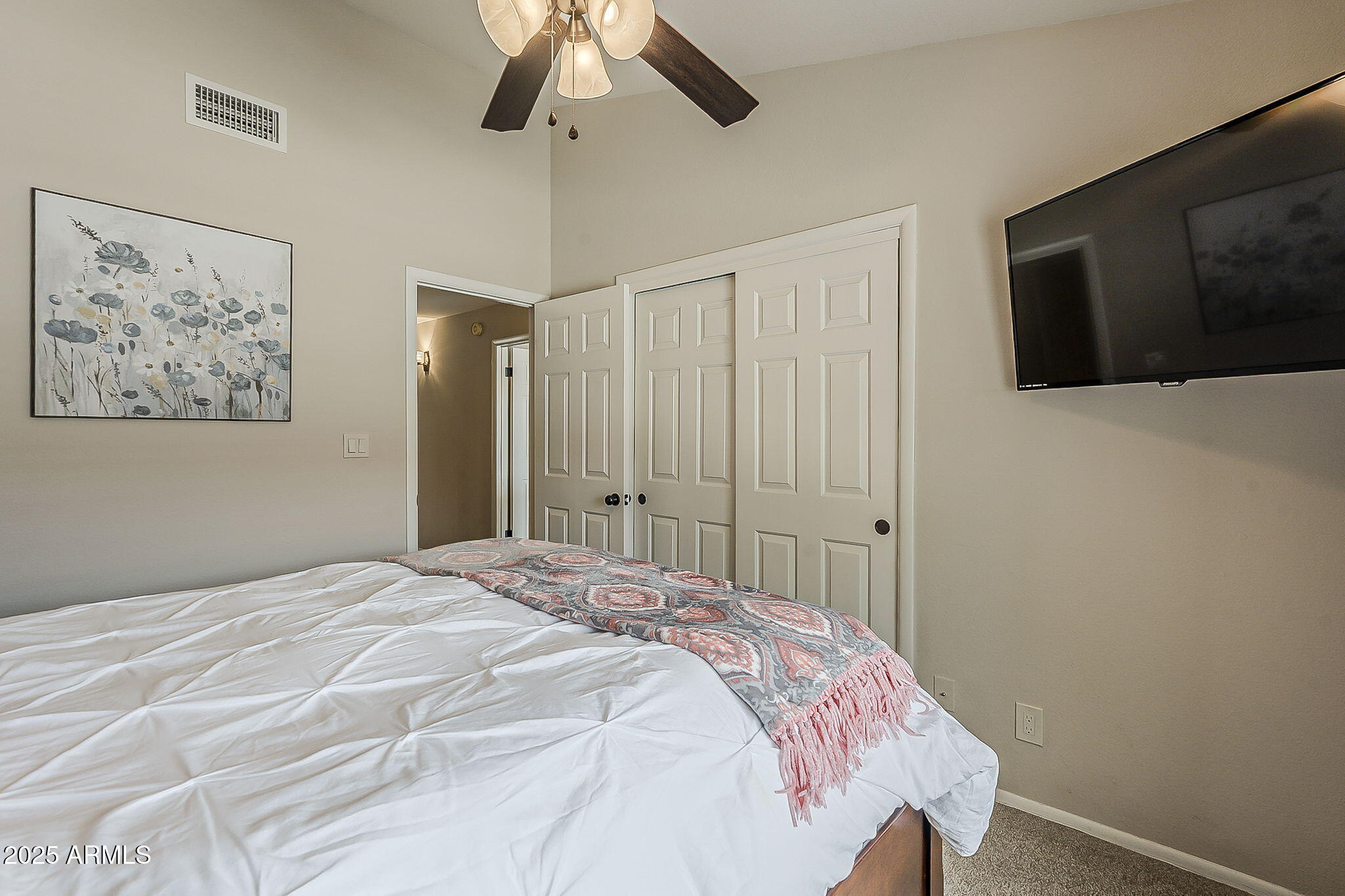 9707 East Mountain View Road, Unit 2412 Scottsdale, AZ 85258 - Photo 30 of 43 a bedroom with a large bed and a chandelier