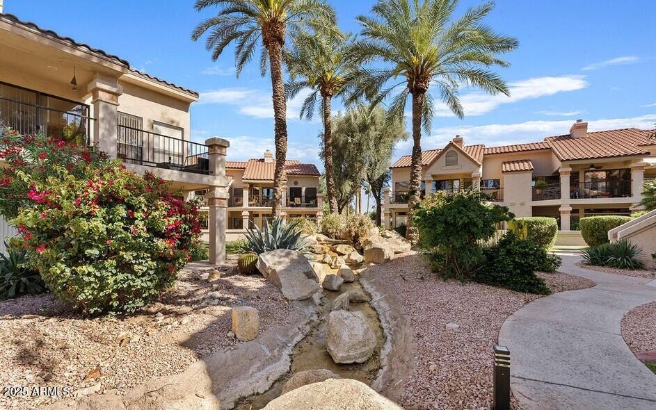 9707 East Mountain View Road, Unit 2412 Scottsdale, AZ 85258 - Photo 38 of 43 a view of a house with a yard and garden