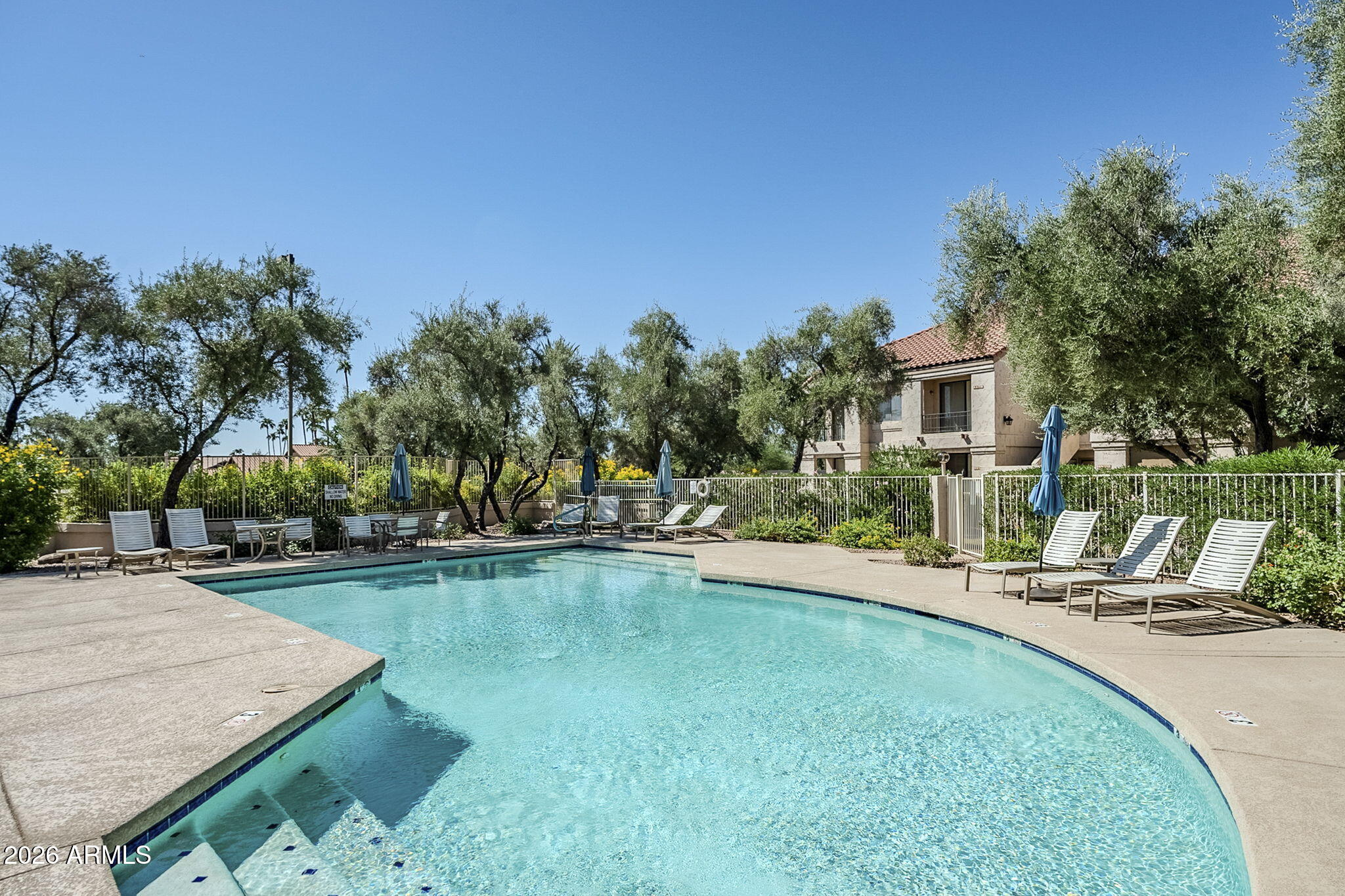 9707 East Mountain View Road, Unit 2412 Scottsdale, AZ 85258 - Photo 60 of 61 a view of a swimming pool and lounge chairs