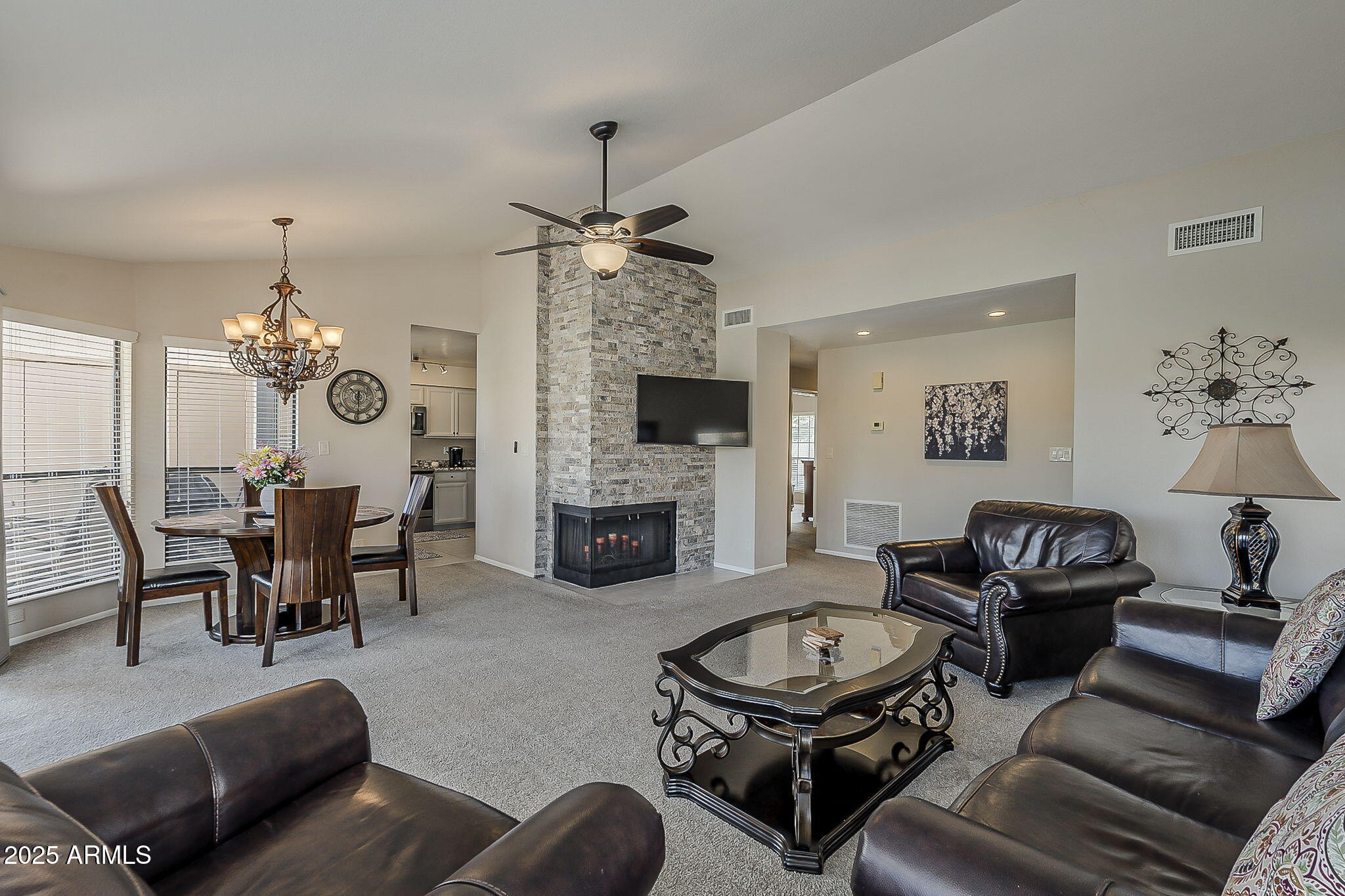 9707 East Mountain View Road, Unit 2412 Scottsdale, AZ 85258 - Photo 10 of 43 a living room with furniture a fireplace and a chandelier