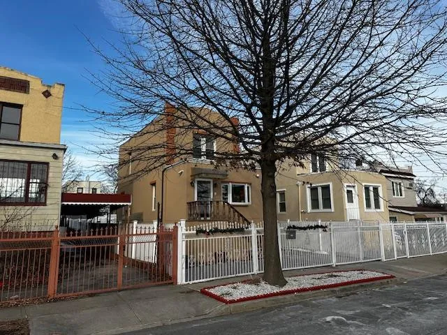 a front view of a house with a tree