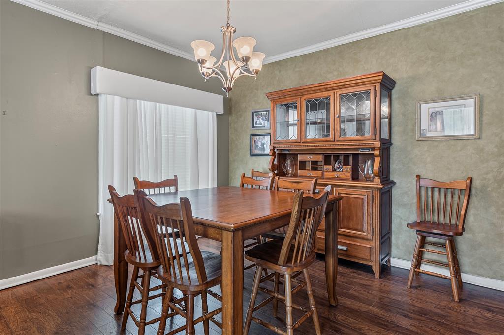 1302 Culver Street Commerce, TX 75428 - Photo 14 of 40 a view of a dining room with furniture a chandelier and wooden floor