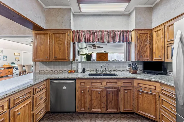 a kitchen with stainless steel appliances granite countertop a sink a stove and cabinets
