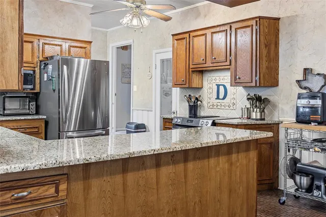 a kitchen with stainless steel appliances granite countertop a sink a stove and a refrigerator