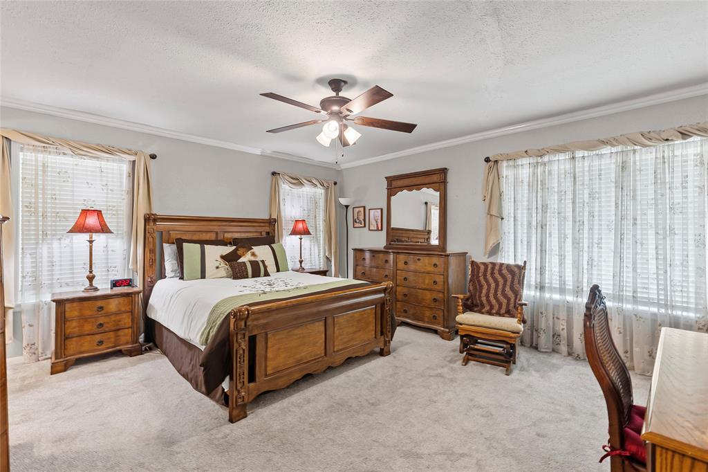 1302 Culver Street Commerce, TX 75428 - Photo 20 of 40 a bedroom with a bed and a chandelier