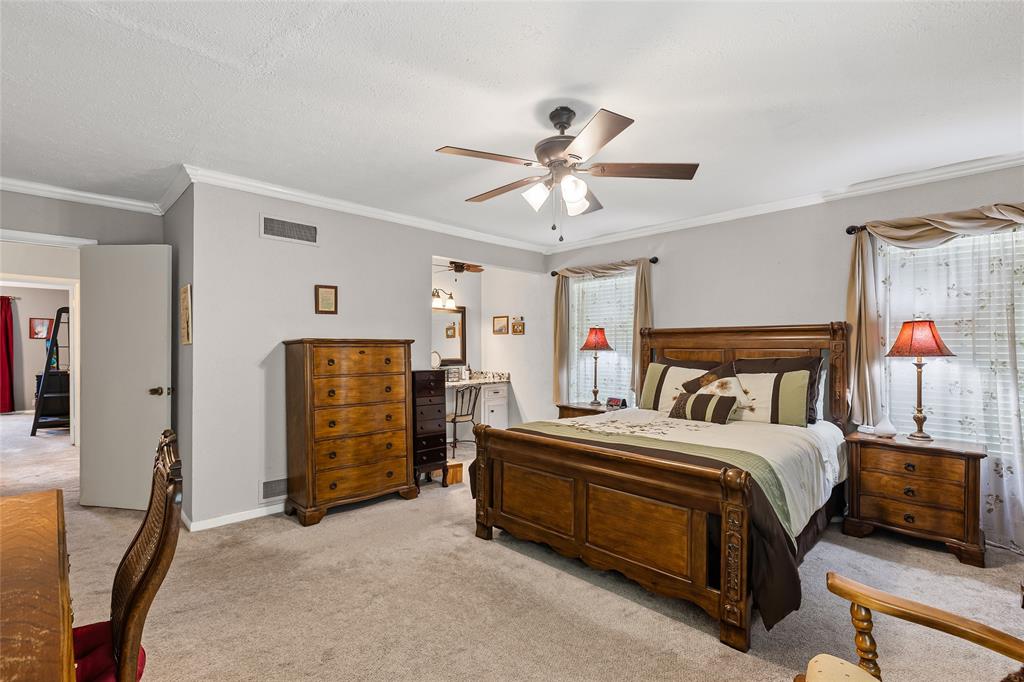 1302 Culver Street Commerce, TX 75428 - Photo 21 of 40 a bedroom with a bed and a ceiling fan