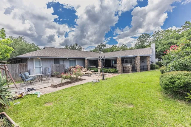 a view of a house with backyard sitting area and garden