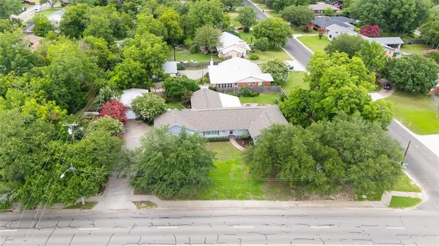 an aerial view of a house with a yard and lake view