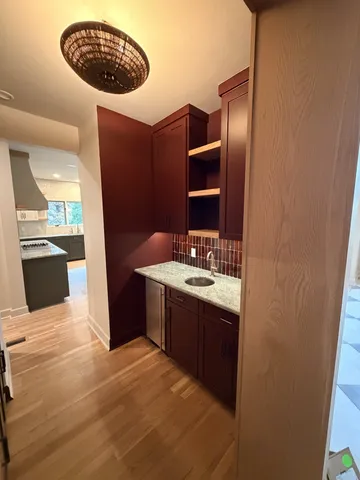 a view of a hallway with wooden floor and a living room