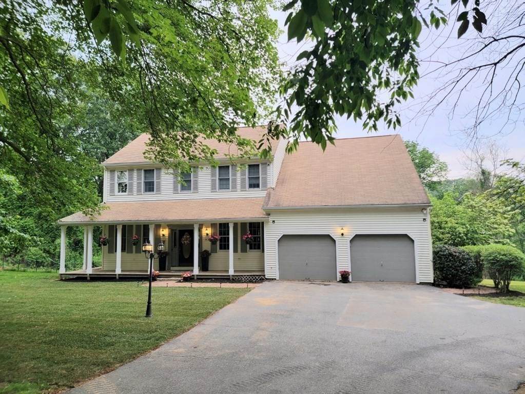 a front view of a house with a yard and trees