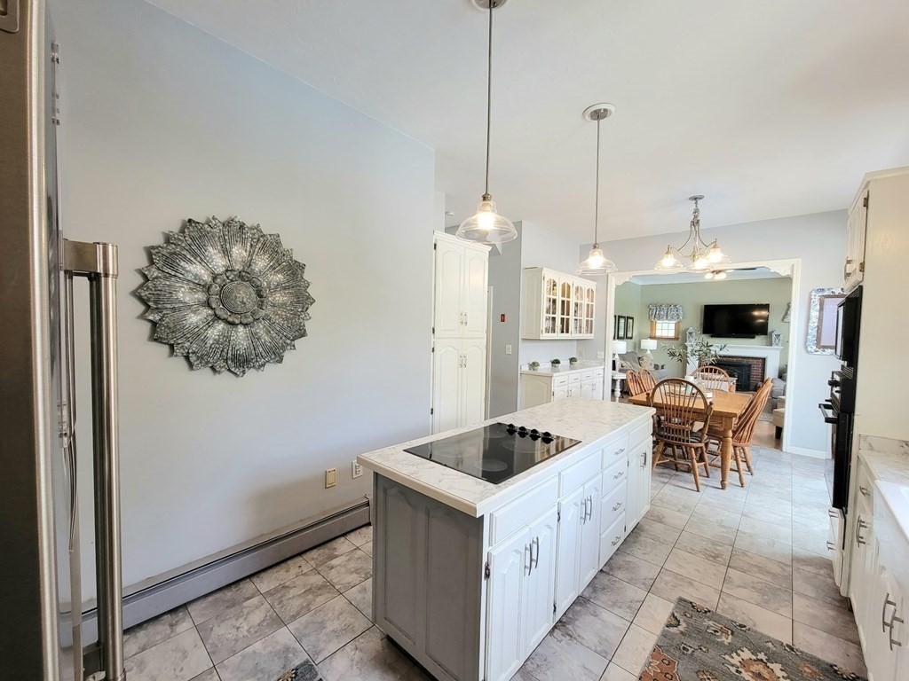 43 Mendon Road Sutton, MA 01590 - Photo 9 of 37 a kitchen with stainless steel appliances kitchen island granite countertop a table chairs and a refrigerator