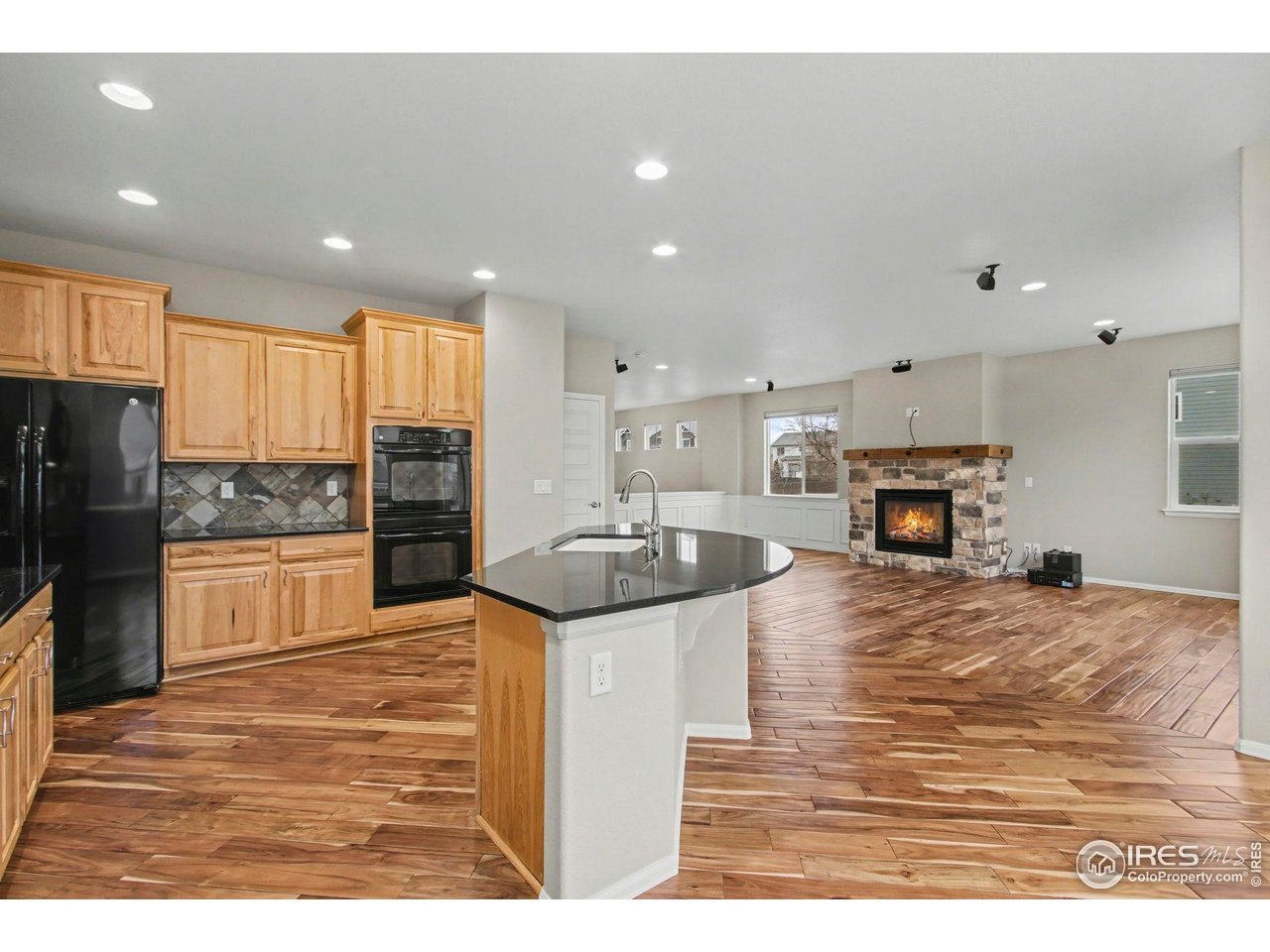 5894 Graphite Street Timnath, CO 80547 - Photo 13 of 50 a kitchen with stainless steel appliances kitchen island granite countertop a refrigerator a stove a sink a oven with a dining table and chairs