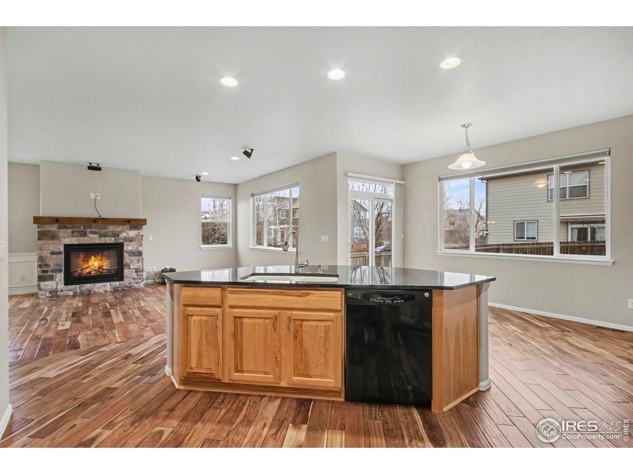 5894 Graphite Street Timnath, CO 80547 - Photo 15 of 50 a open kitchen with granite countertop a stove a sink a refrigerator dining table and chairs
