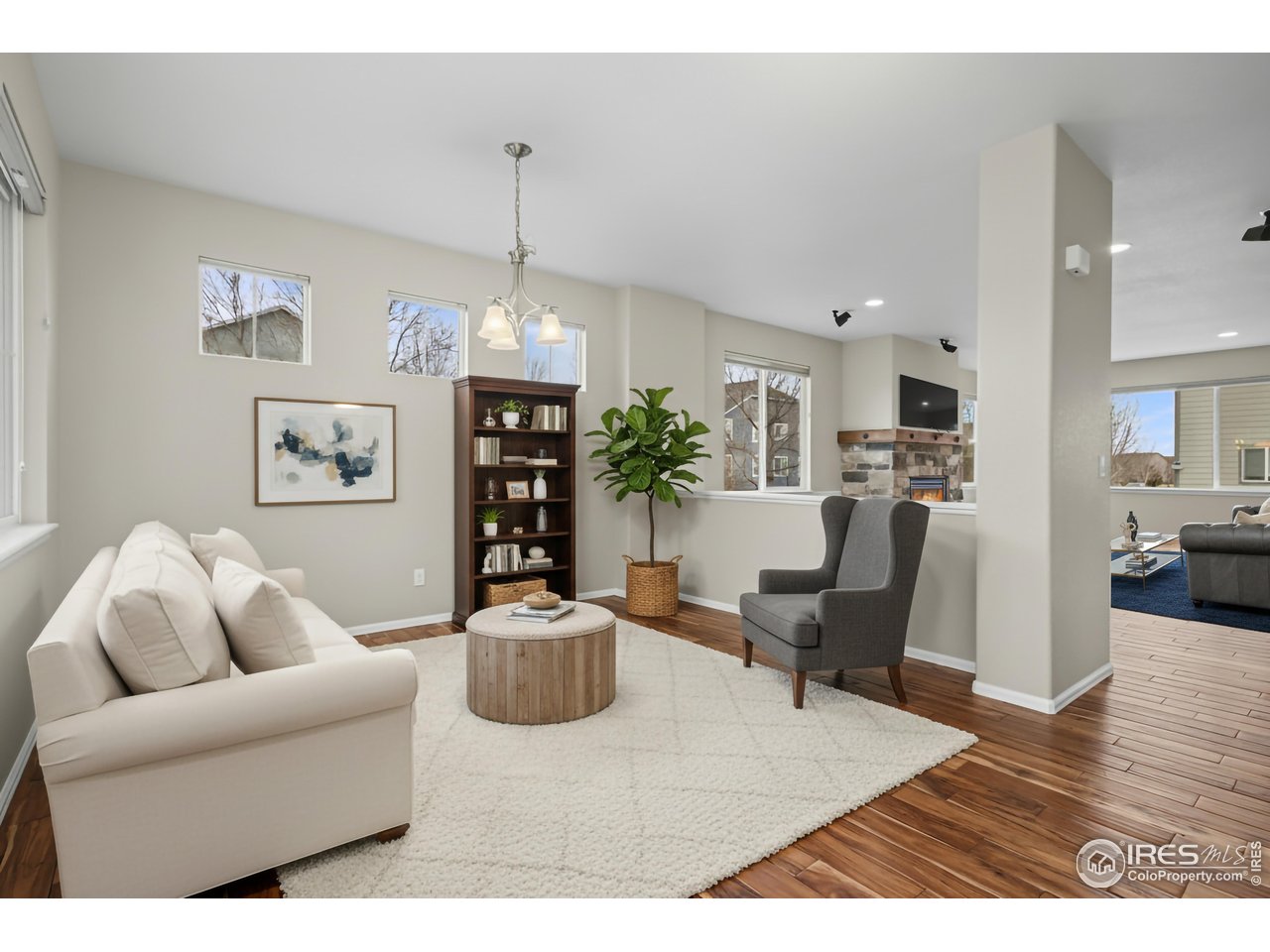5894 Graphite Street Timnath, CO 80547 - Photo 21 of 50 a living room with furniture dining table and a wooden floor