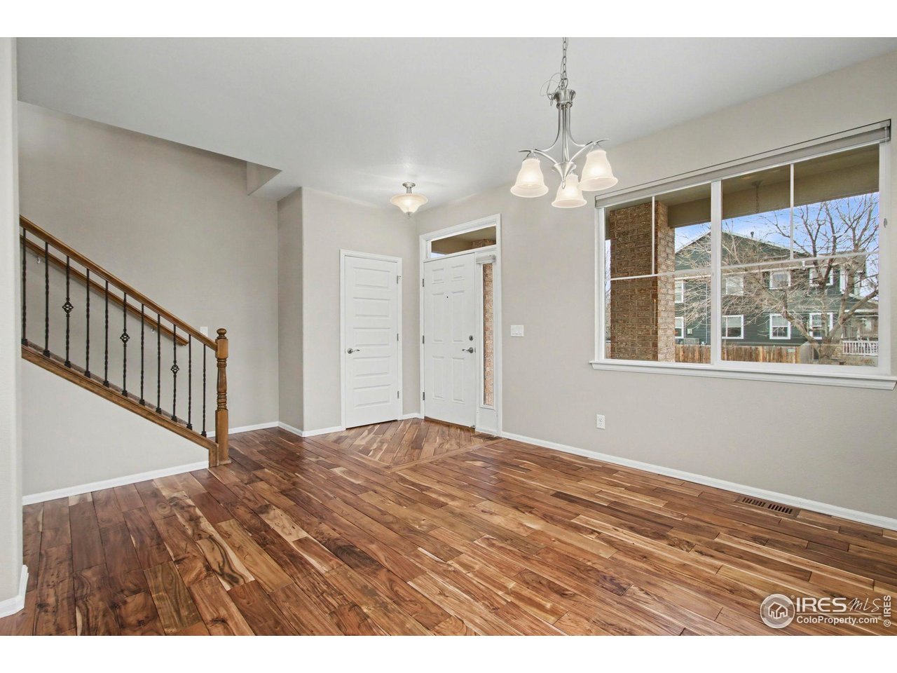 5894 Graphite Street Timnath, CO 80547 - Photo 22 of 50 a view of empty room with wooden floor and windows