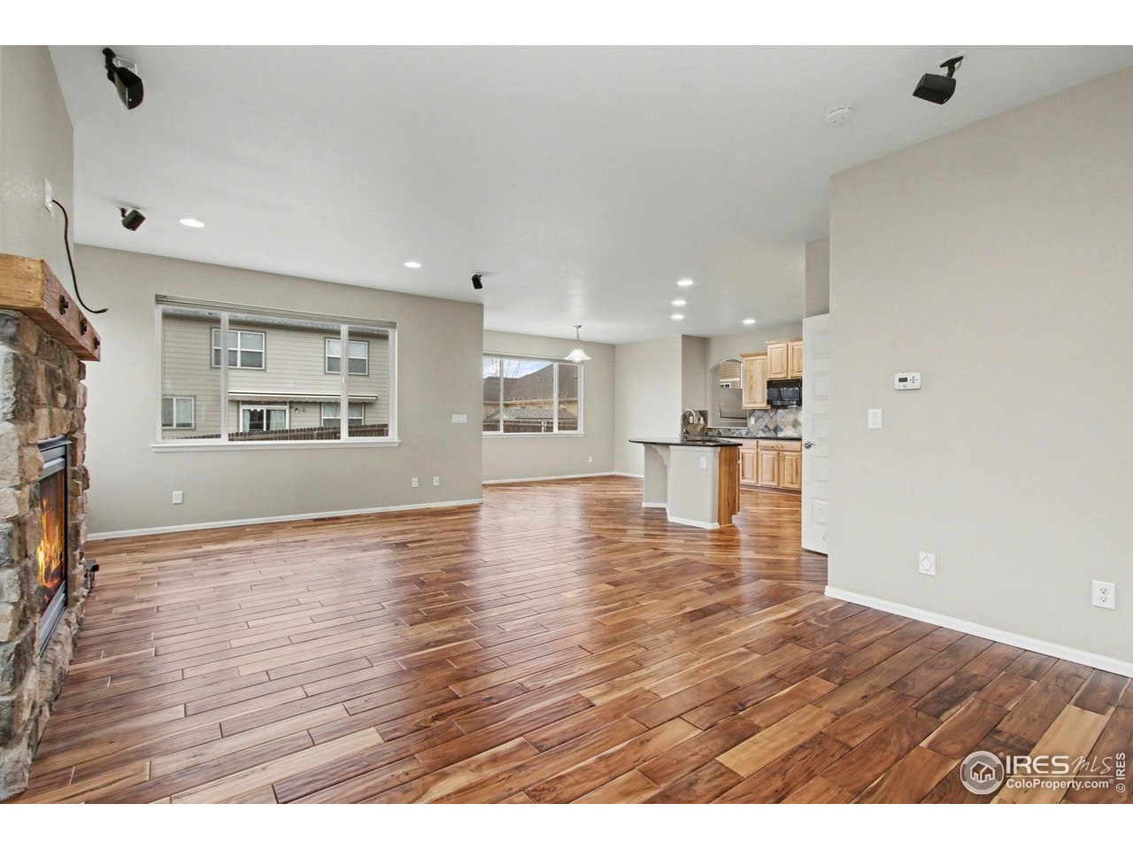 5894 Graphite Street Timnath, CO 80547 - Photo 8 of 50 a view of an empty room with wooden floor and a window
