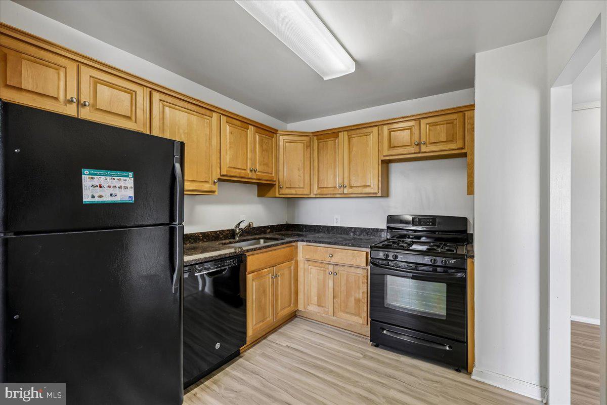 1111 University Boulevard West, Unit 1106A Silver Spring, MD 20902 - Photo 10 of 35 a kitchen with stainless steel appliances granite countertop a stove a refrigerator and a stove