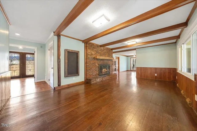 a view of a hallway with wooden floor and dining room