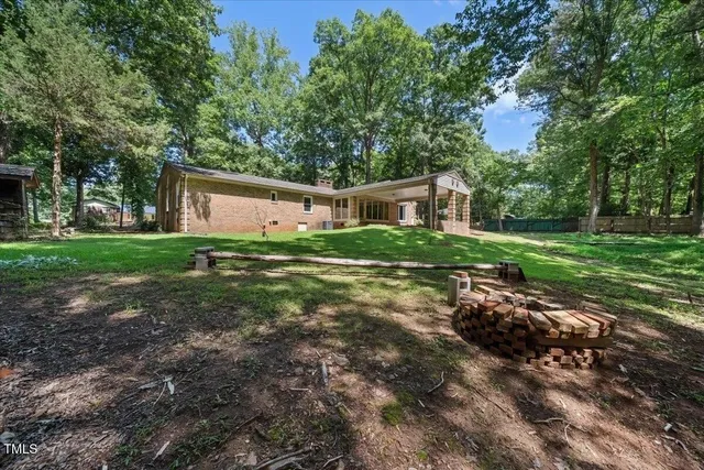 a backyard of a house with large trees and plants