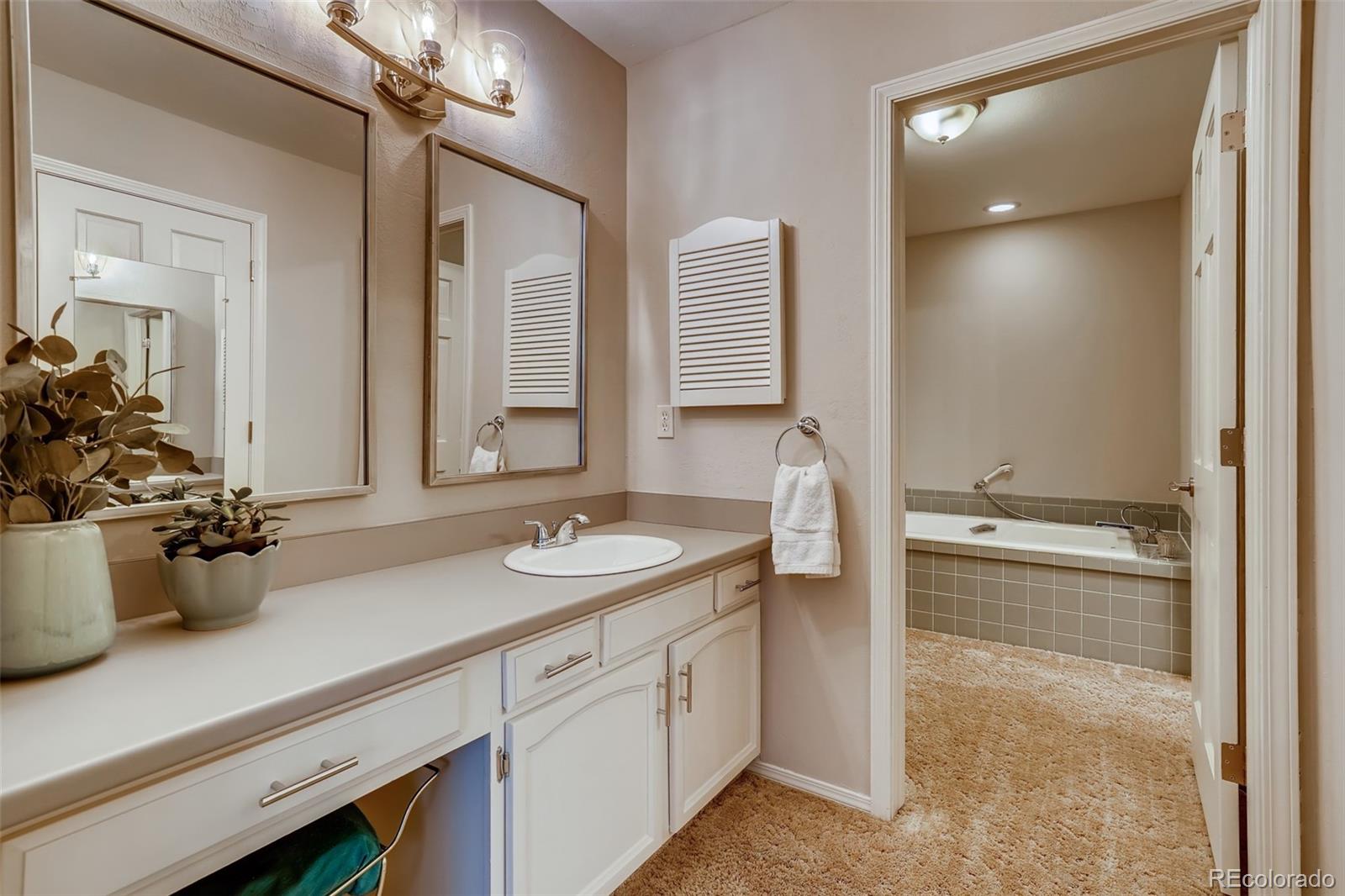 8022 West 78th Way Arvada, CO 80005 - Photo 18 of 30 a bathroom with a sink double vanity granite and a mirror