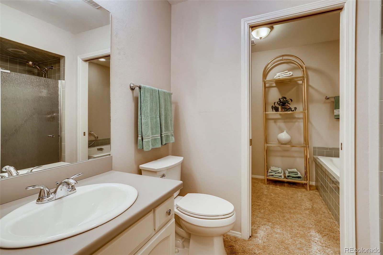 8022 West 78th Way Arvada, CO 80005 - Photo 21 of 30 a bathroom with a toilet sink and mirror