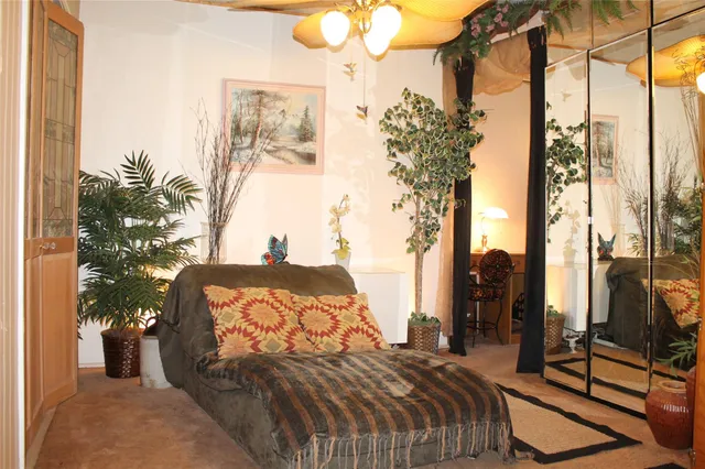 a bedroom with a bed and a potted plant