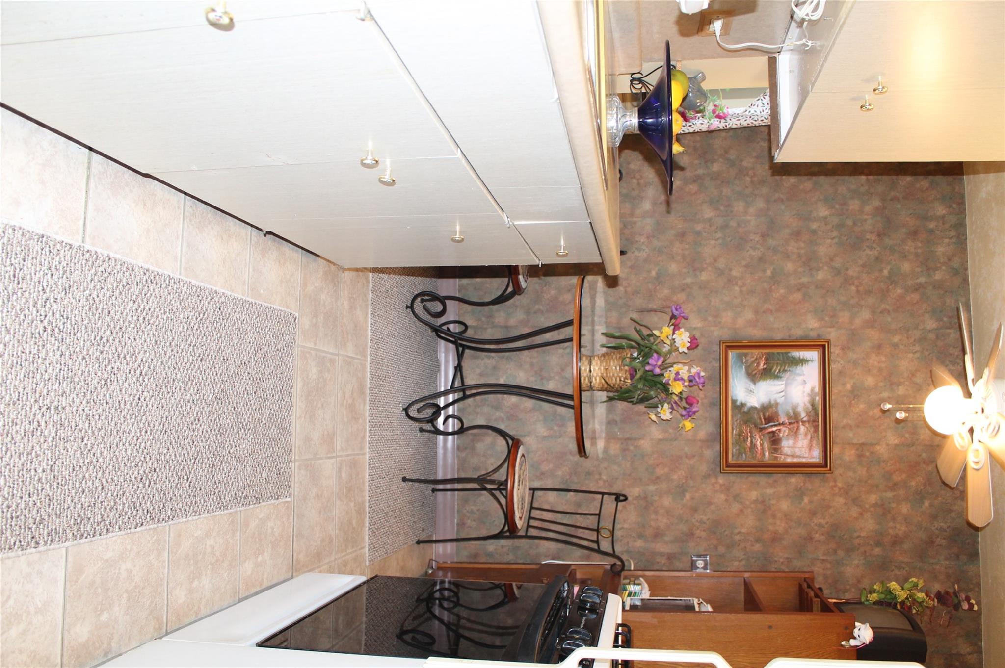 87-10 204th Street, Unit A62 Queens, NY 11423 - Photo 13 of 16 a view of a kitchen with dining area and chandelier