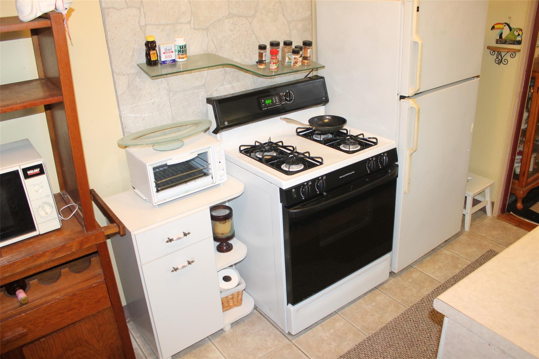 87-10 204th Street, Unit A62 Queens, NY 11423 - Photo 16 of 16 a kitchen with a stove and a microwave