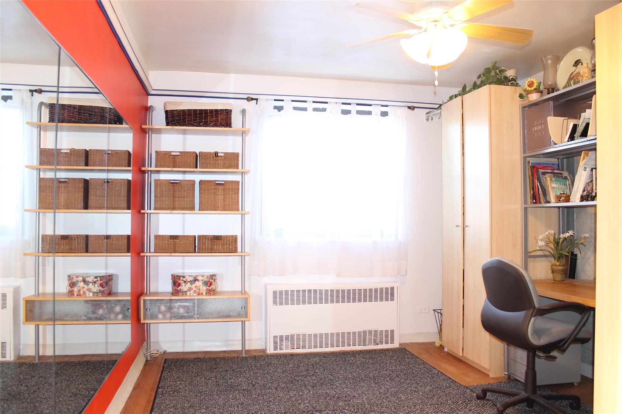 87-10 204th Street, Unit A62 Queens, NY 11423 - Photo 6 of 16 a room with furniture and a book shelf