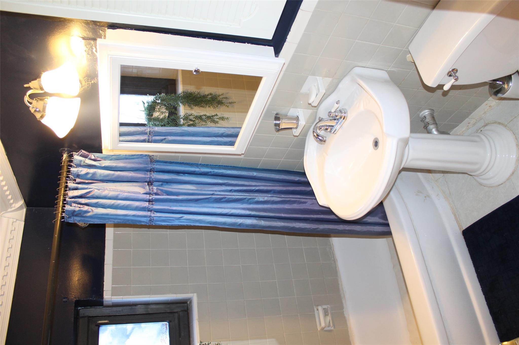 87-10 204th Street, Unit A62 Queens, NY 11423 - Photo 10 of 16 a bathroom with a sink and a mirror