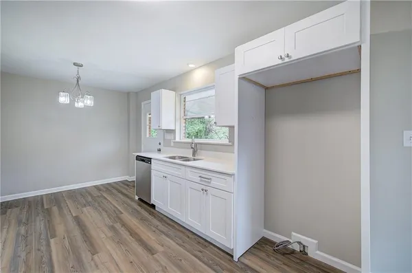 a large kitchen with a sink and dishwasher a stove with wooden floor