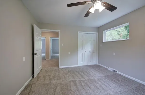 wooden floor in an empty room with a chandelier fan