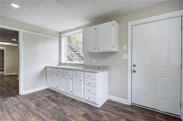 a view of kitchen with granite countertop cabinets and wooden floor